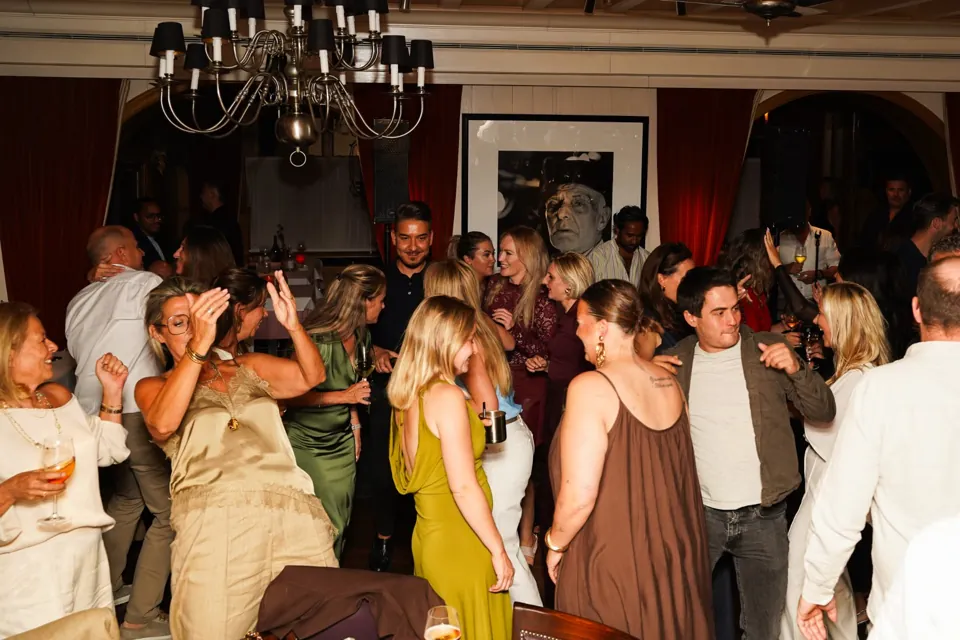 Gasten vieren samen een feest in de Auberge